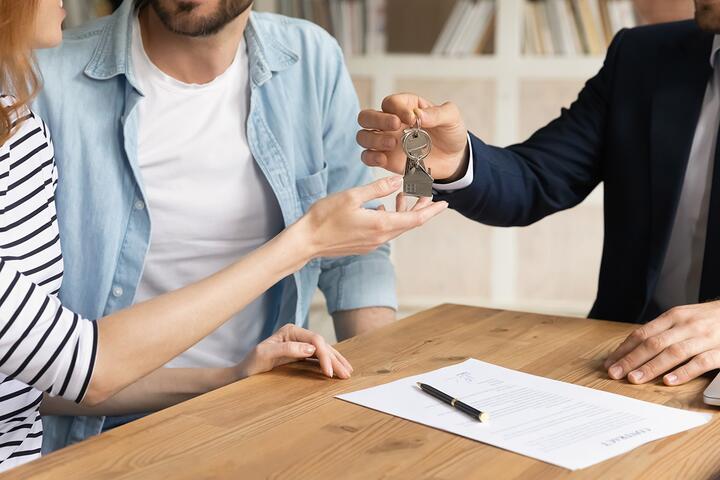 Happy couple receiving house keys after completing a mortgage deal in Portugal.